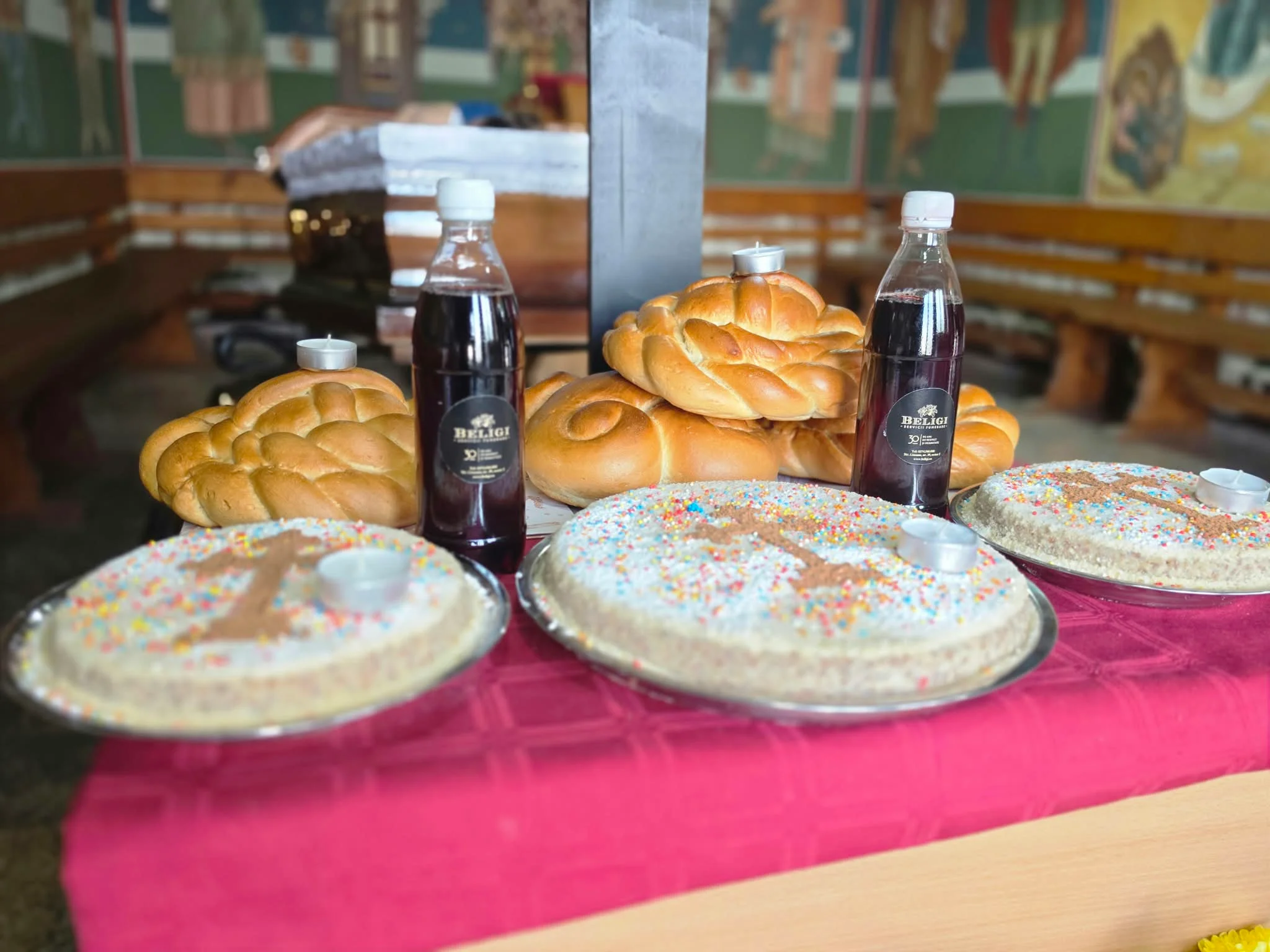 familie asezand coliva si colaci pe masa de pomenire, parastas de 40 zile